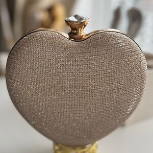 Beautiful heart-shaped clutch bag with an elegant and shiny design.
